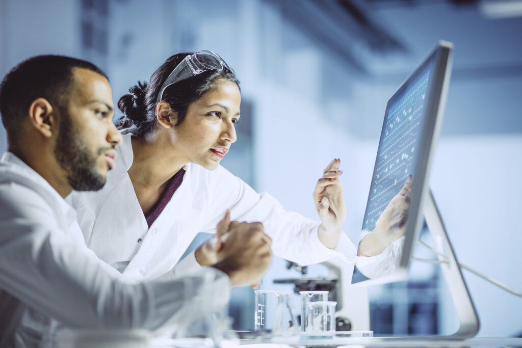 Two clinical researchers analyzing information on a computer